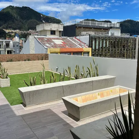 Terraza social terminada de 2051 LOFT, con jardineras en concreto y vista a los cerros orientales