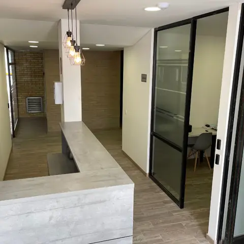 Zona común de 2051 LOFT terminada: recepción y sala de juntas con divisiones en vidrio