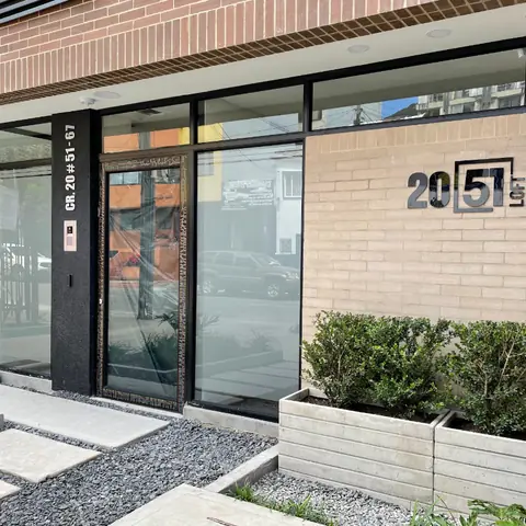 Acceso y portería de 2051 LOFT terminados, con la señalización del edificio sobre la Carrera 20