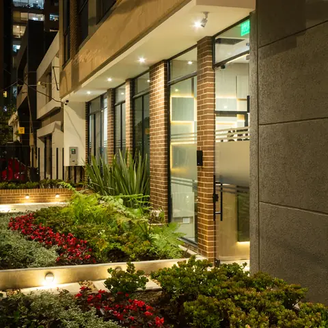 Antejardín iluminado de 4991 LOFT sobre la Carrera 49, con jardinería terminada